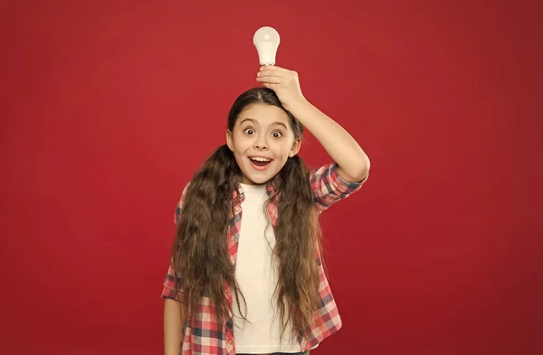 Niño feliz niña mantenga bombilla de la lámpara en la cabeza, idea creativa — Foto de Stock