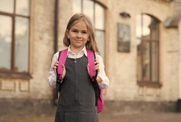 Resmi moda üniformalı küçük bir çocuk okul çantasını dışarıda, okulda taşıyor. — Stok fotoğraf