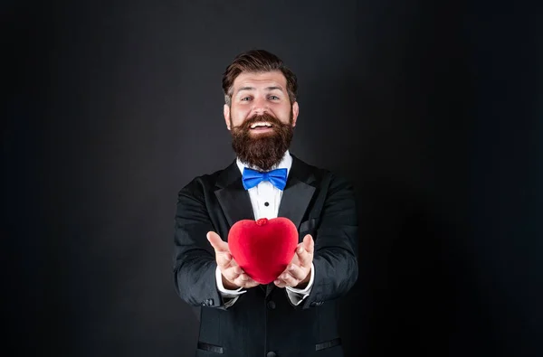 Para ti. Um homem bonito a fazer uma proposta. dom do amor. O homem do smoking feliz partilha o coração. Valentim feliz — Fotografia de Stock