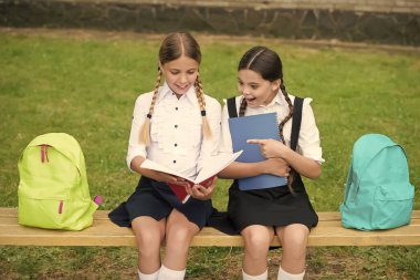 Ne kadar çok okursan, o kadar çok öğrenirsin. Küçük çocuklar bankta oturarak kitap okurlar. Okul eğitimi. Edebiyat dersi. Şiir ödevi. Bilgi ve hayal gücü. Okur yazarlık gelişiminin derinliklerinde