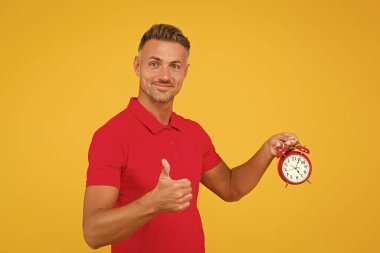 O her zaman dakiktir. Dakik adam çalar saati tutar, parmaklarını yukarı kaldırır. Zamanında gelmeyi seviyorum. Tam zamanında geldin. Dakiklik ve doğru zaman tutma. Saat gibi düzenli