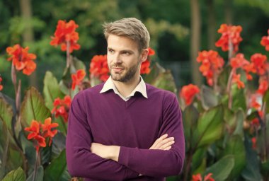 Kendine güvenen adamın elleri çapraz, şık saçları ve kılları var, erkek güzeli.