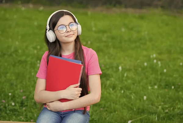 夏のメロディーを聞く女の子ワイヤレスヘッドフォン自然背景、趣味とレジャーの概念 — ストック写真