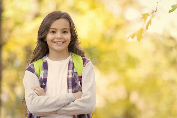 Teen girl carry backpack on the way to school. child walk in autumn forest. fall leaves in park. seasonal weather. childhood happiness. beauty and nature. happy kid wear casual style. copy space — Stock Photo, Image