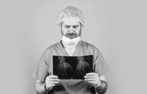 Man kijk naar roentgen. Radioloog houdt röntgenfoto. De dokter onderzoekt de röntgenfoto. X-stralen van handen. verpleegster controleert röntgenfoto 's in het ziekenhuis. gezondheidsproblemen. Operatie en medisch concept — Stockfoto