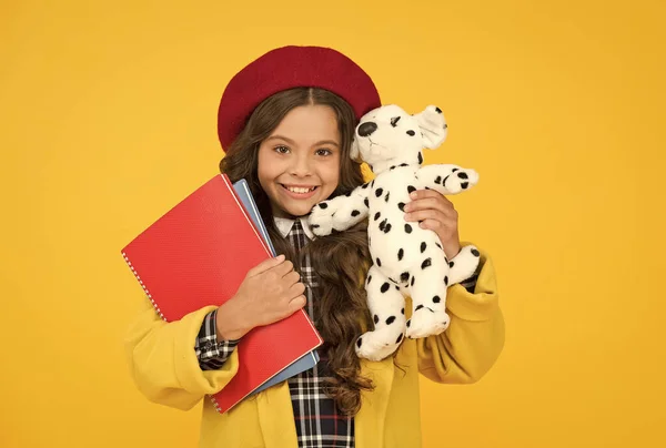 Criança feliz segurar brinquedo filhote de cachorro bonito e caderno de trabalho, felicidade — Fotografia de Stock