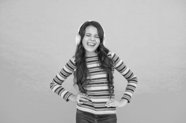 Enerjik ritim kavramı. İyi parça havayı iyileştirir. Mutlu küçük kız müzik dinliyor. Küçük çocuk kulaklıkla çalan şarkılardan hoşlanır. Gülen surat. Müzik mutlu duygular getirir. Neşelendirmek için melodi