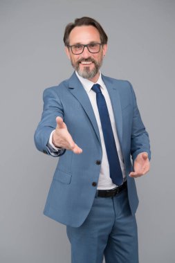 Hoş geldin jesti olarak elini uzat. Yakışıklı, kendine güvenen iş adamı. Gözlüklü orta yaşlı bir adam. Zeki ve zeki görünüyor. Sakallı ve gözlüklü adam kendinden emin. Mutlu görünümlü iş adamı