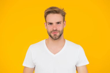 Yakışıklı genç adam. Tıraşsız yakışıklı bir adam. Tüylü hippi beyaz tişört giyer. Yakışıklı adam poz veriyor. Karizmatik maço. Yakışıklı, seksi adam. Karizma konsepti. Yüz bakımı. Güzel insanlar.