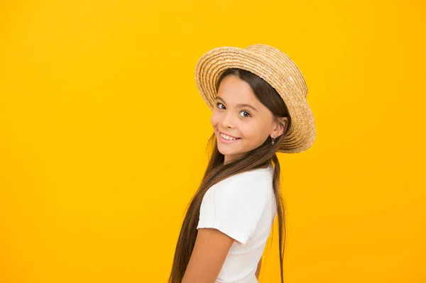Κοριτσάκι ομορφιά. Το παιδί φοράει ψάθινο καπέλο. Χαρούμενο κοριτσάκι με κίτρινο φόντο. Χαρούμενη ημέρα των παιδιών. Παιδική καλοκαιρινή μόδα. Είναι έτοιμη για πάρτι στην παραλία. Επιτέλους καλοκαιρινές διακοπές. αντίγραφο χώρου — Φωτογραφία Αρχείου