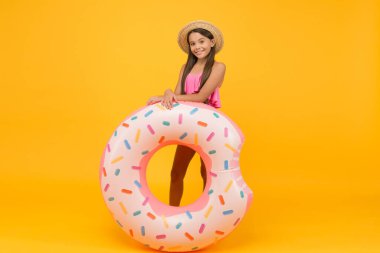Rest at seaside. Pool party. Happy childhood. Entertainment concept. Little girl and swimming donut ring. Kid in swimsuit having fun water activities. Swimming and sunbathing. Summer vacation