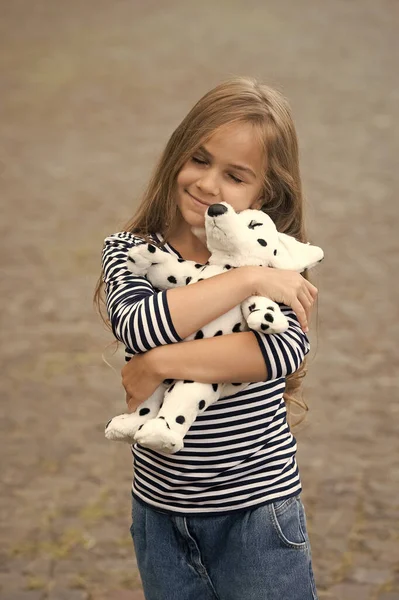 因为你的孩子应该得到照顾快乐的孩子在户外抱着玩具狗.爱和关心。游戏与发展。玩具商店。分享快乐 — 图库照片