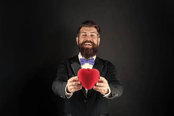 Бородатый мужчина в формальном смокинге разделяют любовь сердце на 14 февраля День святого Валентина, избирательный фокус, любовь — стоковое фото