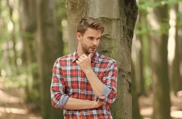 Bellezza e moda maschile. Il tizio con le setole indossa una camicia a scacchi. stile moda casual. uomo muscoloso nella foresta. sexy macho in camicia sbottonata all'aperto. giovane uomo unshaven ha curato i capelli — Foto Stock