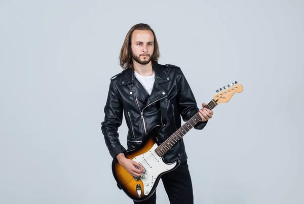 Balancim barbudo em jaqueta de couro. homem cabelo longo tocar guitarra elétrica. estilo de música rock. — Fotografia de Stock