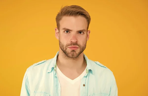 Knappe ongeschoren man met haar. mannelijke zomer casual mode stijl. serieuze man heeft geprepareerd haar op gele achtergrond. menselijke emoties. sexy jongen met trendy kapsel overhemd — Stockfoto