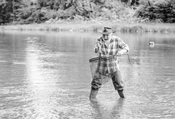 渔民捕鱼设备。2.户外运动。只有渔夫一个人站在河水里.一个大胡子渔夫退休金领取者的闲暇时间。商业养鱼养殖 — 图库照片