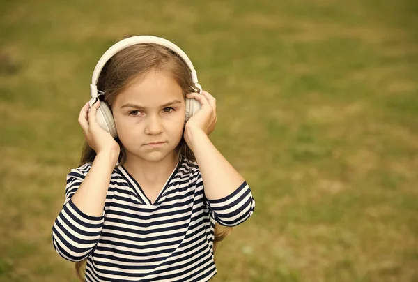 真剣にかわいい子供は、屋外、サウンド、コピースペースのヘッドフォンの夏の風景で演奏音楽を聴く — ストック写真
