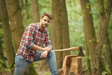 İş bitti. Kamp ve yürüyüş. Açık hava aktivitesi. Baltalı güçlü bir adam. Oduncu mu? Çiftlik adamı baltayı taşır. Seksi adam ormanda gömlek giyer. Erkek gücü ve enerji. Kamp alanında yakacak odun.