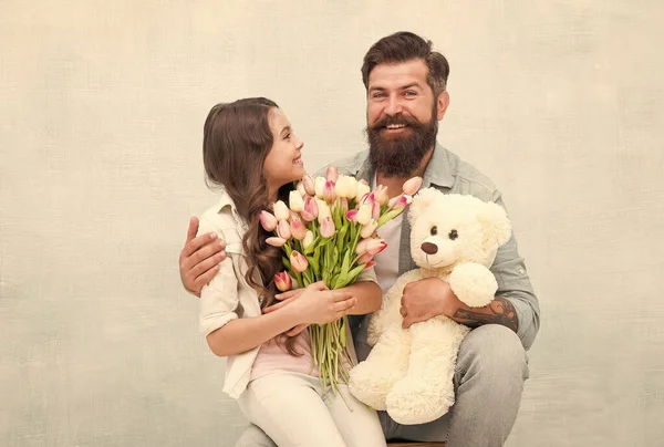 Wishing happy anniversary. Happy family celebrate anniversary. Father and daughter hold tulips and toy. Fathers day. Womens day. Birthday anniversary. Holiday celebration. International childrens day — Stock Photo, Image