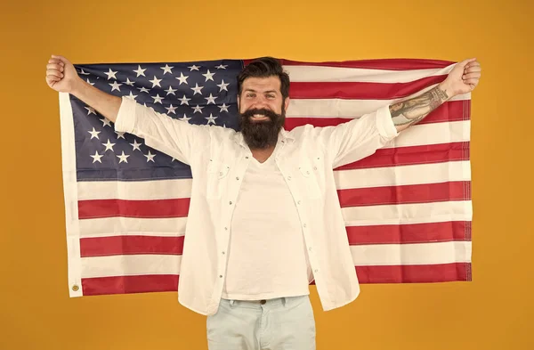 A celebrar a independência. O hipster feliz celebra o dia da independência. Homem barbudo segurar bandeira americana fundo amarelo. Dia da independência. 4 de Julho. Independência das nações — Fotografia de Stock