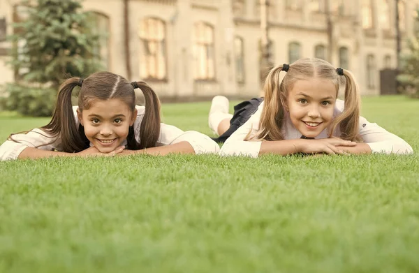 Ottimo posto per ricevere cure. Bambini felici rilassarsi sull'erba verde. Prodotti per la cura della pelle. Cura della pelle estiva. Cosmetici per capelli. Cura dei capelli. Salone di bellezza. Assistenza all'infanzia e assistenza sanitaria pediatrica — Foto Stock