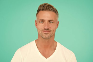 Yakışıklı, tıraşsız adam. Yüzünde kıllar olan yakışıklı bir adam. Yüz kılı bakımı. Erkek bakımı modası. Berber dükkanı güzellik salonu. Olgun gülümseyen adam. Sıradan tarz mavi gözlü adam.