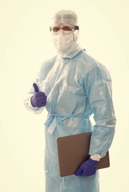 Koruyucu kostümlü bir tıp işçisi beyazlar üzerinde izole edilmiş 19 sarar virüsü salgınından korunmak için internetten çalışan defter ve koronavirüs sonuçları.