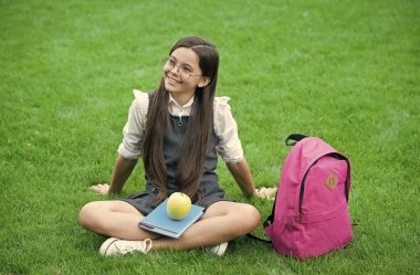 Ara vermek için en iyi zaman. Mutlu çocuk yeşil çimlerde rahatla. Okul tatili. Yemek molası. Sağlıklı beslenme ve atıştırma. Vejetaryen yemeği. Beslenme eğitimi. Sağlıklı vücut sağlıklı yiyecekler yer.