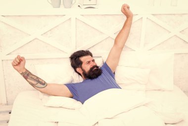 Güzel bir sabah. Tembel pazar. Yatak zamanı rutini. Vahşi erkek esneme hareketleri. Rahat yaşam tarzı konsepti. Yatakta sakallı bir adam. Sabah erken kalkarım. Bekar rahat hisset. Adam yatak odasında dinleniyor.