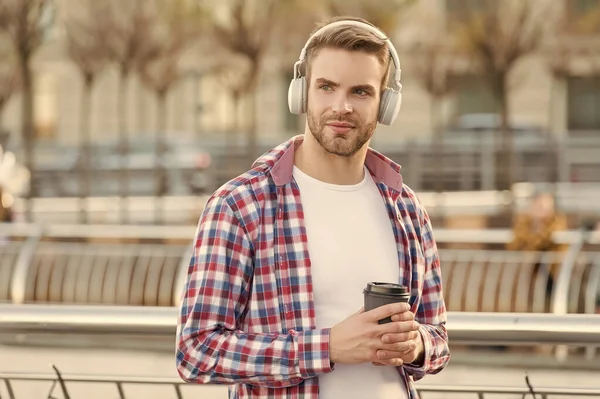 Getting warm with fresh coffee. man in headphones listen audio book. businessman working outdoor. smart casual dressed person drinking coffee outdoor. Caucasian male resting in street listening music — Stock Photo, Image