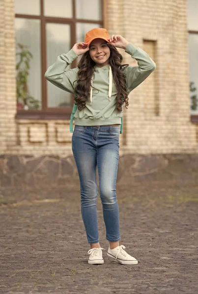 Menina feliz corrigir boné elegante com aparência de moda vestindo roupas casuais em ambientes urbanos ao ar livre, hipster — Fotografia de Stock