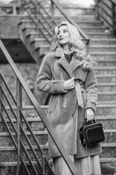 Feeling cold. sexy blong woman. autumn season. european winter. girl warm coat stairs background. faux fur coat fashion. stylish business lady leather bag. glamour girl look luxuriously — Stock Photo, Image