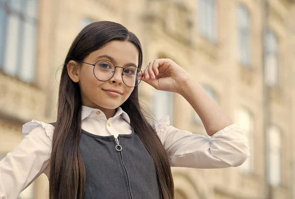 Bambino piccolo fissare gli occhiali occhi rotondi incorniciati indossando formale uniforme scolastica all'aperto, visione. istruzione formale — Foto Stock