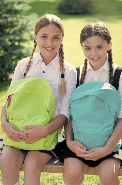 Yaz parkında mutlu gülümseyen öğrenciler. Okul çantalı kızlar. Sırt çantalı çocuk. Mutlu zamanlar. Parkta sırt çantalı küçük kızlar. Sırt çantalı çocuklar gülümsüyor — Stok fotoğraf