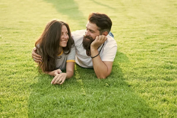 一对无忧无虑的夫妇在绿茵的草地上享受着阳光普照的日子，浪漫的约会理念 — 图库照片