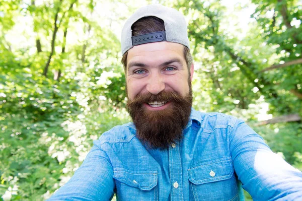 Glad mogen skäggig man med skägg och mustasch gör selfie foto i sommarskogen, selfie — Stockfoto