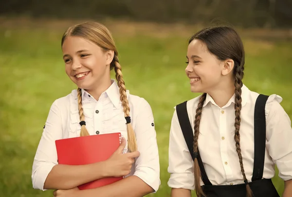 Gelukkige kinderen in staartjes glimlachen in formele uniformen na schooldag buiten, geluk — Stockfoto