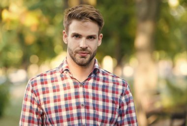 Tüylü yakışıklı adam, kareli gömlek giyiyor, erkek modasında.