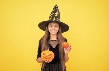 Cadılar bayramı çocuğu cadı şapkasıyla balkabağı tutuyordu. Büyücülük için balkabağı tutuyordu. Cadılar Bayramı balkabağı.