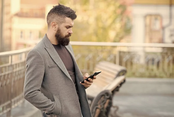 Llegar a la gente sobre la marcha con el marketing de SMS. Hombre barbudo leer sms urbano al aire libre. Mensajería de texto. Dispositivo móvil. Nueva tecnología. La vida moderna. Comunicación empresarial — Foto de Stock