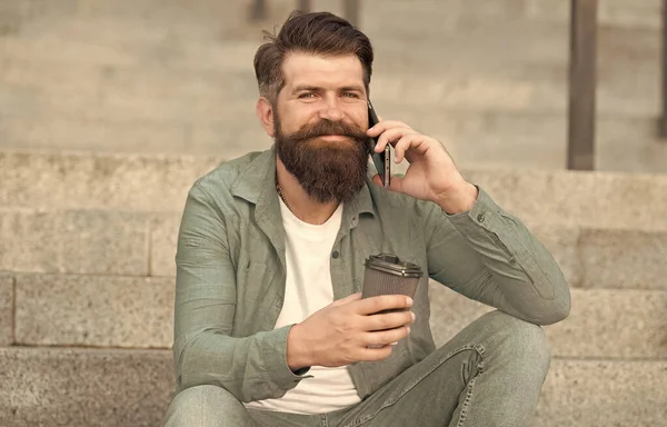 Koffie pauze. Persoonlijke communicatie. Ik bel een vriend. Aangenaam gesprek. Een echte connectie. Drink koffie terwijl je praat. Modern stadsleven. Een telefoongesprek met een baard. Mobiel gesprek — Stockfoto