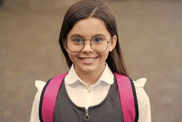 Buon sorriso carino bambino indossando occhiali in uniforme scolastica all'aperto, futuro — Foto Stock