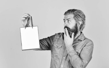 Sakallı adam kese kağıdı tutuyor. Hediyeler. İnternetten alışveriş yapan mutlu adam. Hipster 'ın elektronik mağazasından alışveriş yapmasına şaşırdım. Alışverişten hoşlanan olumlu bir adam. Kendi işim var. En iyisini seçmek.