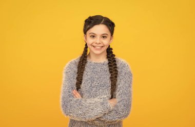 Kendinden emin hissediyorum. Mutlu çocukluk. Küçük kızın güzel bir gülümsemesi var. Çocuk saç stili. Uzun saçlı bir çocuk. Kuaförden sonra neşeli bir genç. Saçları örgülerle örülmüş. Çapraz elli küçük güzellik