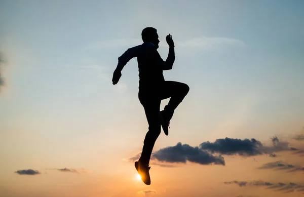 Energieke man runner silhouet loopt naar de toekomst tegen zonsondergang hemel, succes — Stockfoto