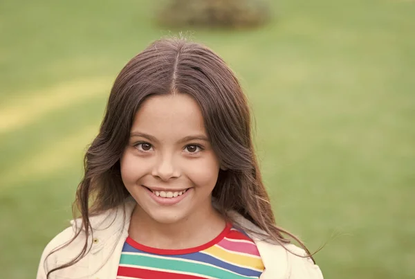 Eu sou uma criança feliz. Aluna alegre. Menina bonito miúdo grama verde. Criança feliz emocional relaxando ao ar livre. Férias. Ideias de férias. Menina sorridente feliz desfrutar relaxar no gramado. Retrato de perto — Fotografia de Stock