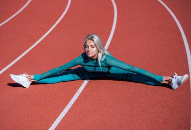 Esnek kadın sporcu esneyip ısınıyor. Ayrılıp ısınıyor.