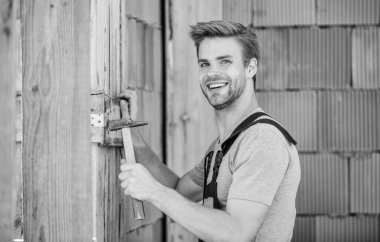 Çekiç aletli bir mühendis. Çekiç tuğlalı arka planı olan bir işçi. Bina ve inşaat. Genel bakım ve onarım işçileri bakım ve onarım işleri için işe alınır. Çekiç kullan