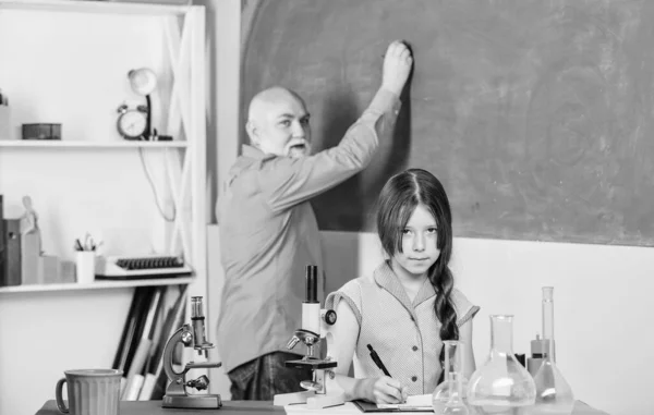 Lição de biologia fascinante. aula de ciências. Microscopia. Equipamento de laboratório. menina pequena com homem tutor estudar química. professor maduro de biologia. Aluna no laboratório da escola. usar lupa — Fotografia de Stock